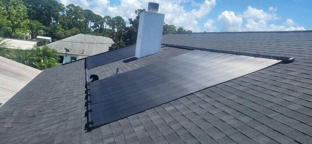 Solar pool heating collectors installed around residential roof features