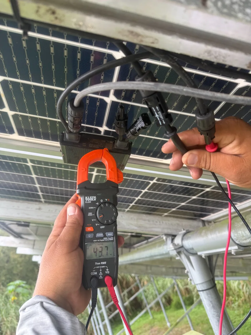 DC voltage testing beneath a Canadian Solar ground-mounted array in Deltona, Florida.