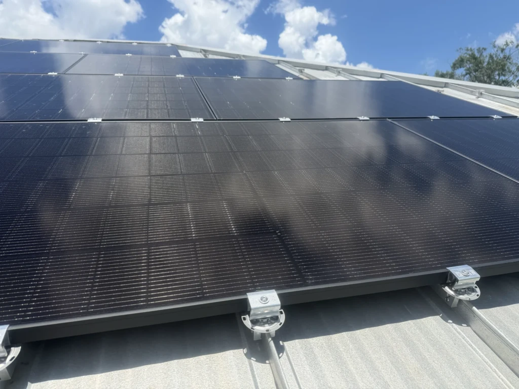 Black solar modules beneath a bright Florida sky